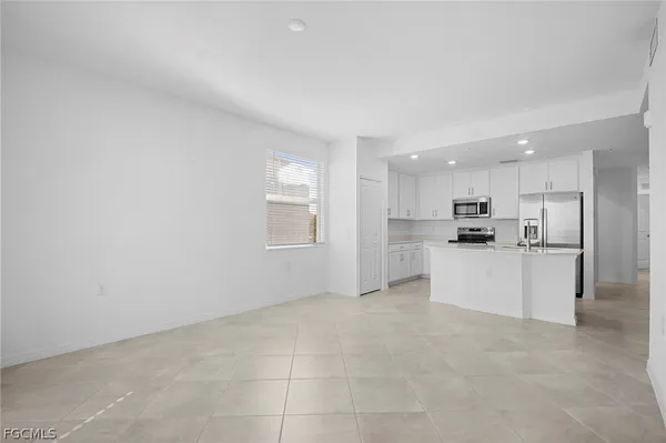 a view of kitchen with kitchen island white cabinets and refrigerator