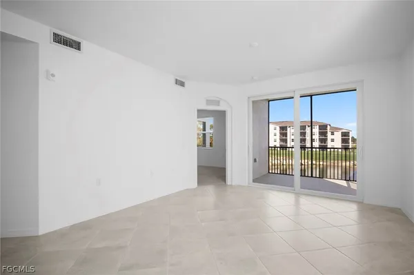 an empty room with floor to ceiling window and wooden floor
