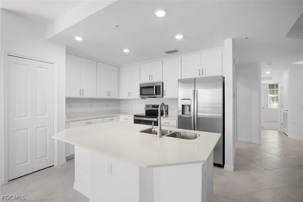 a kitchen with stainless steel appliances a refrigerator sink and microwave