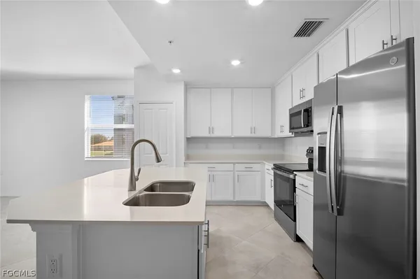 a kitchen with stainless steel appliances granite countertop a sink dishwasher a refrigerator and a stove