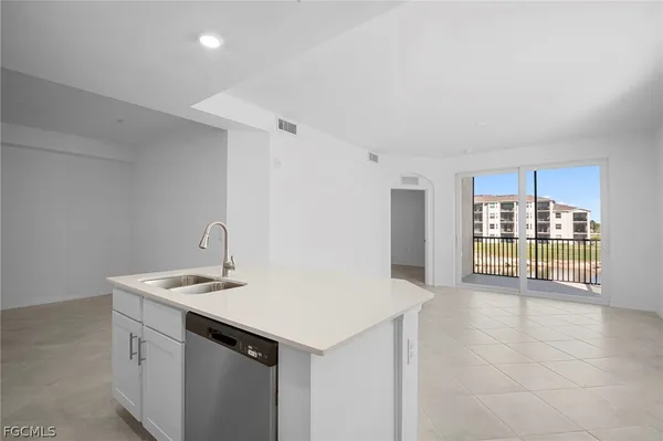a view of an empty room with a kitchen