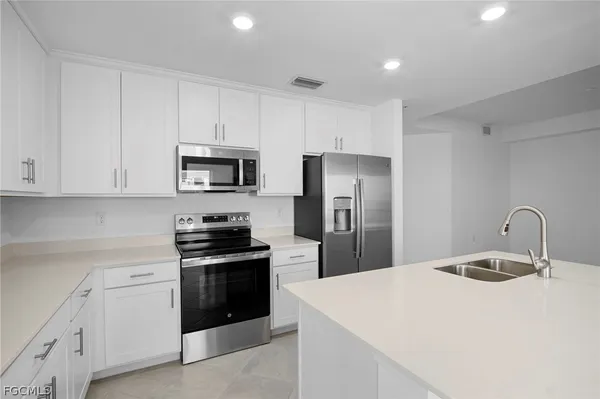 a kitchen with white cabinets and stainless steel appliances