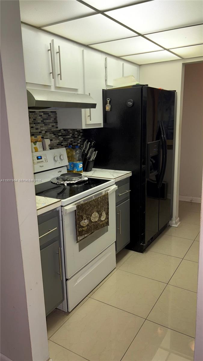 3120 North Pine Island Road, Unit 307 Sunrise, FL 33351 - Photo 13 of 17 a stove top oven sitting inside of a kitchen