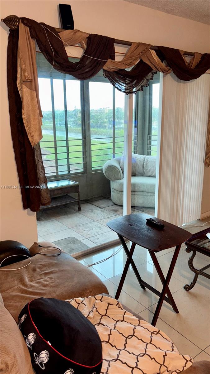 3120 North Pine Island Road, Unit 307 Sunrise, FL 33351 - Photo 2 of 17 a living room with furniture and a floor to ceiling window
