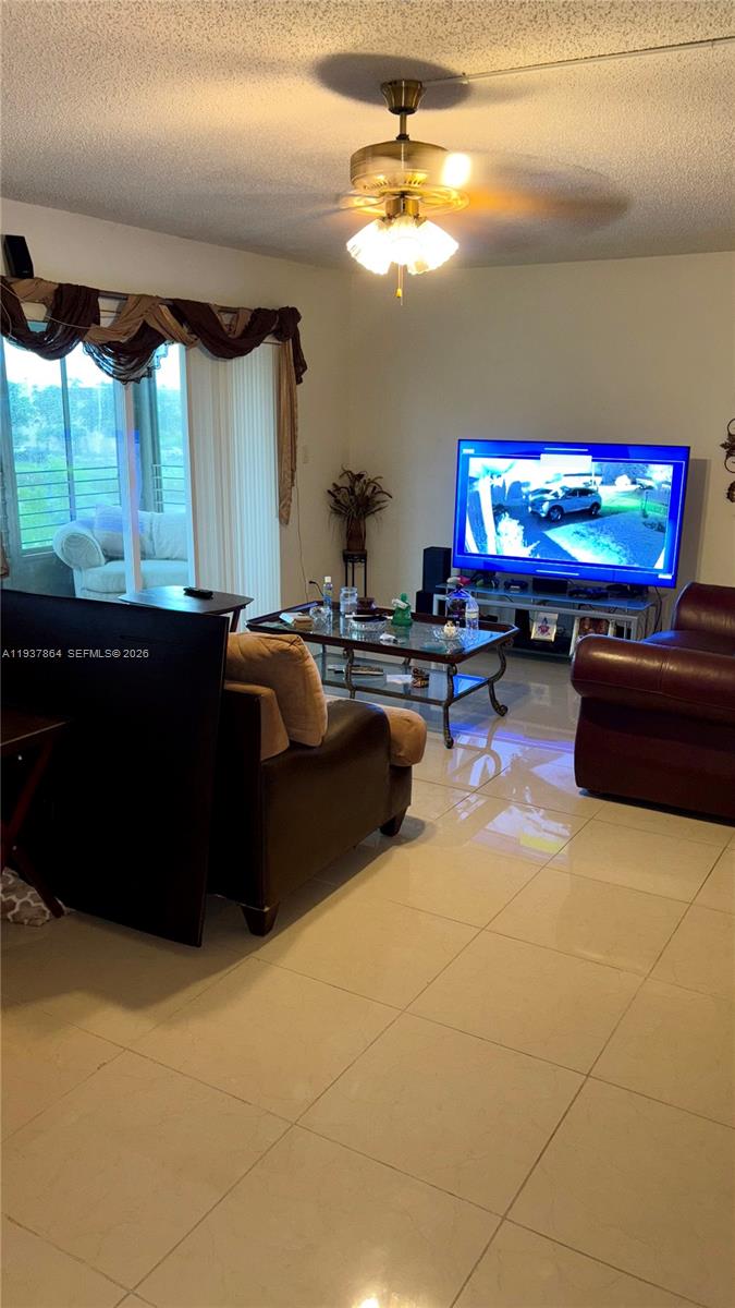 3120 North Pine Island Road, Unit 307 Sunrise, FL 33351 - Photo 10 of 17 a living room with furniture a flat screen tv and a fireplace