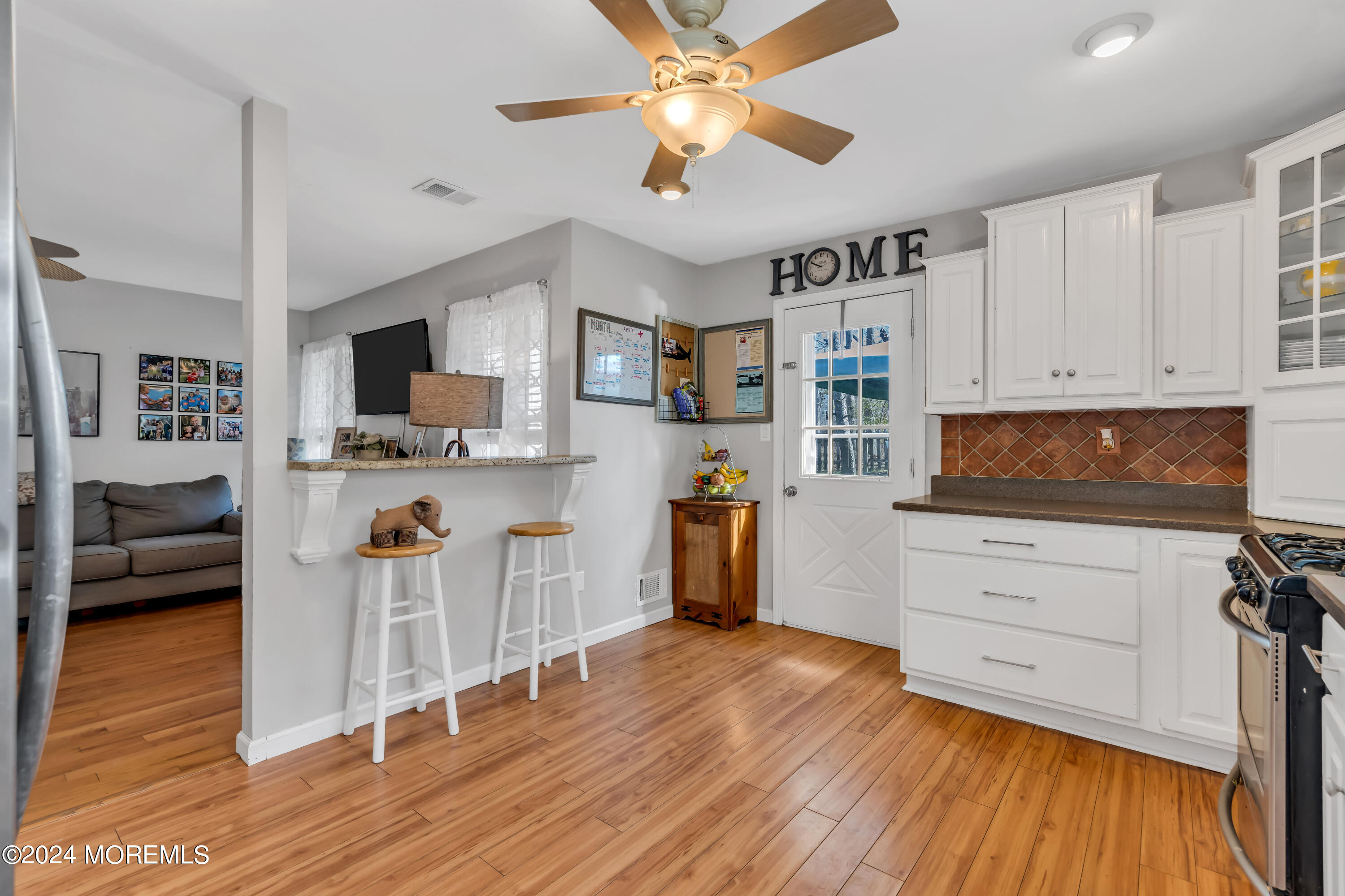 38 Concord Circle Howell, NJ 07731 - Photo 16 of 38 a kitchen with stainless steel appliances wooden floors stove and white cabinets