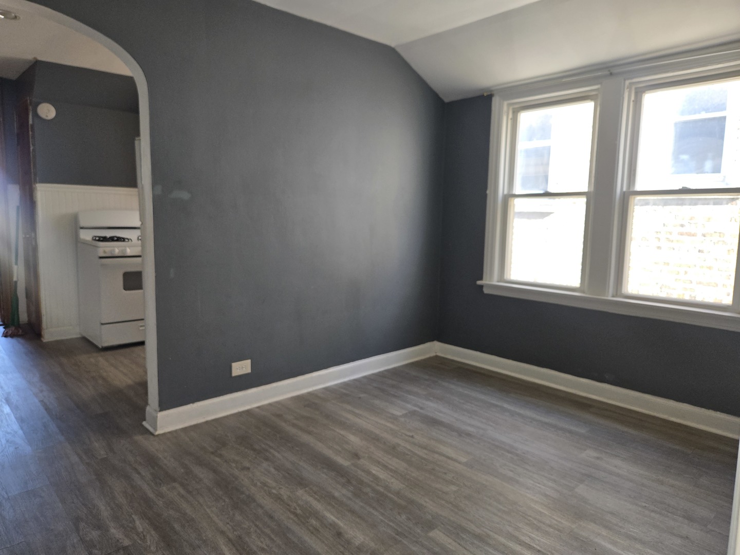 5204 West Newport Avenue, Unit 2 Chicago, IL 60641 - Photo 3 of 10 an empty room with wooden floor and windows