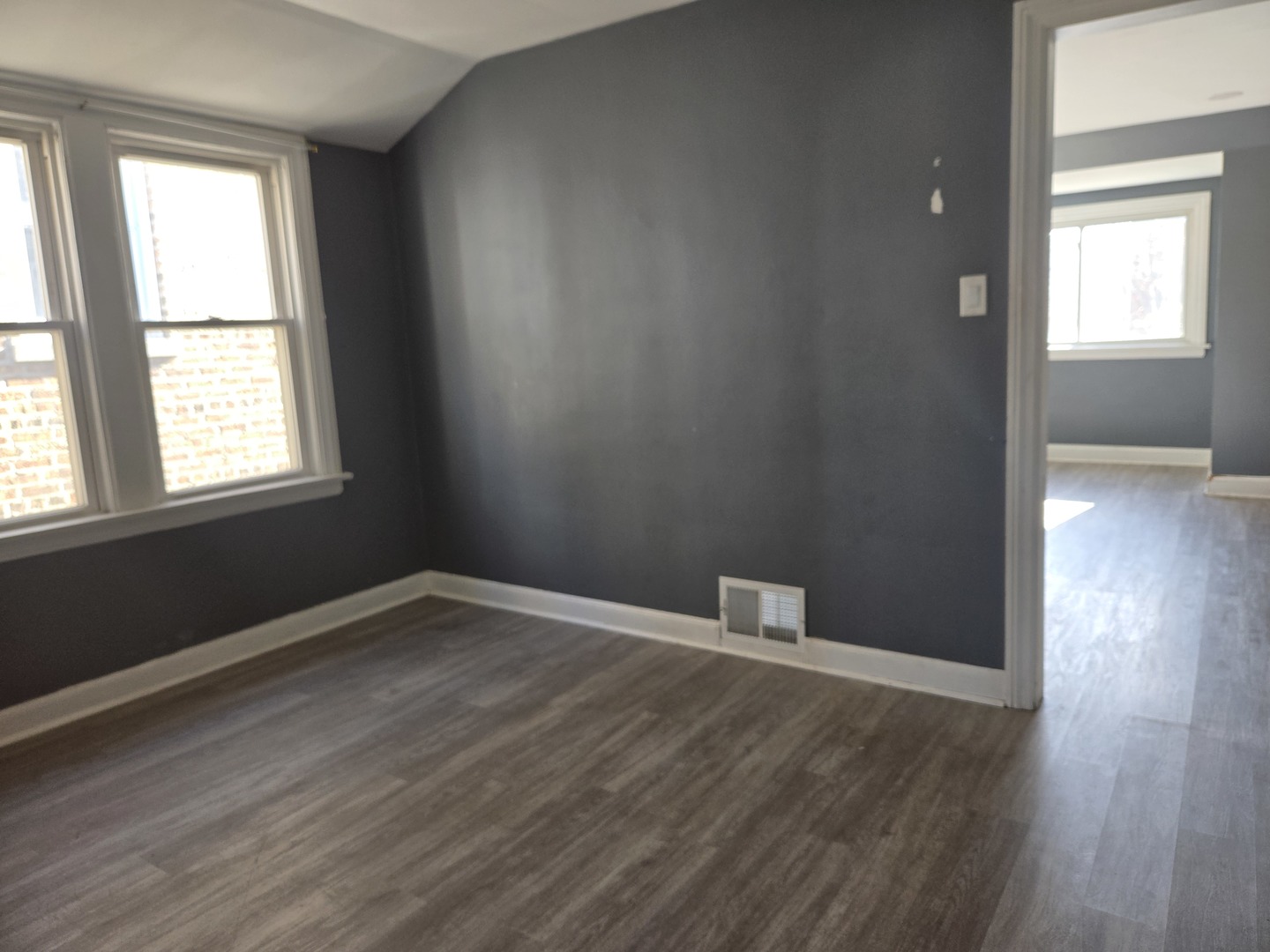 5204 West Newport Avenue, Unit 2 Chicago, IL 60641 - Photo 4 of 10 an empty room with wooden floor and windows