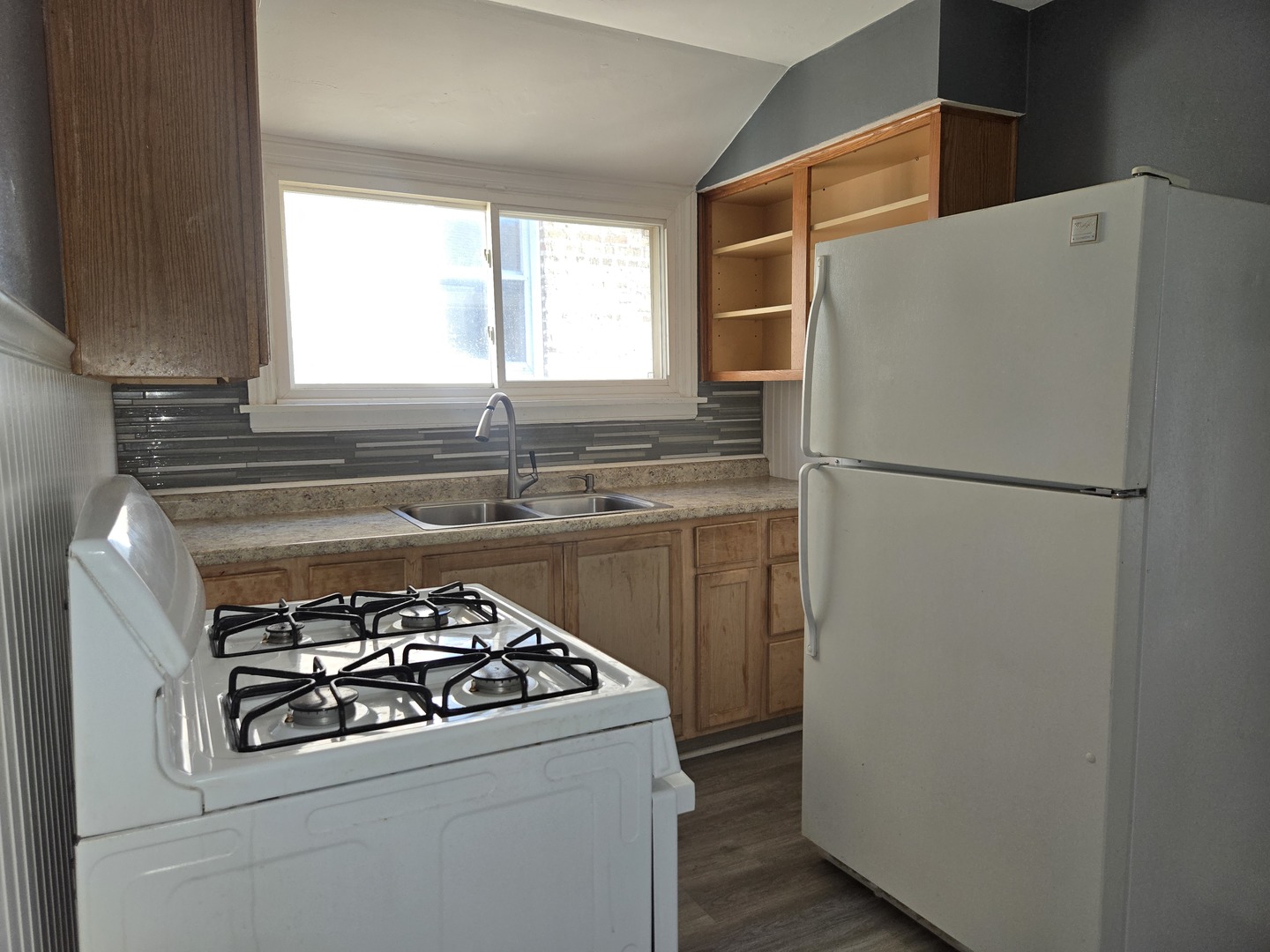 5204 West Newport Avenue, Unit 2 Chicago, IL 60641 - Photo 5 of 10 a kitchen with a refrigerator sink and window