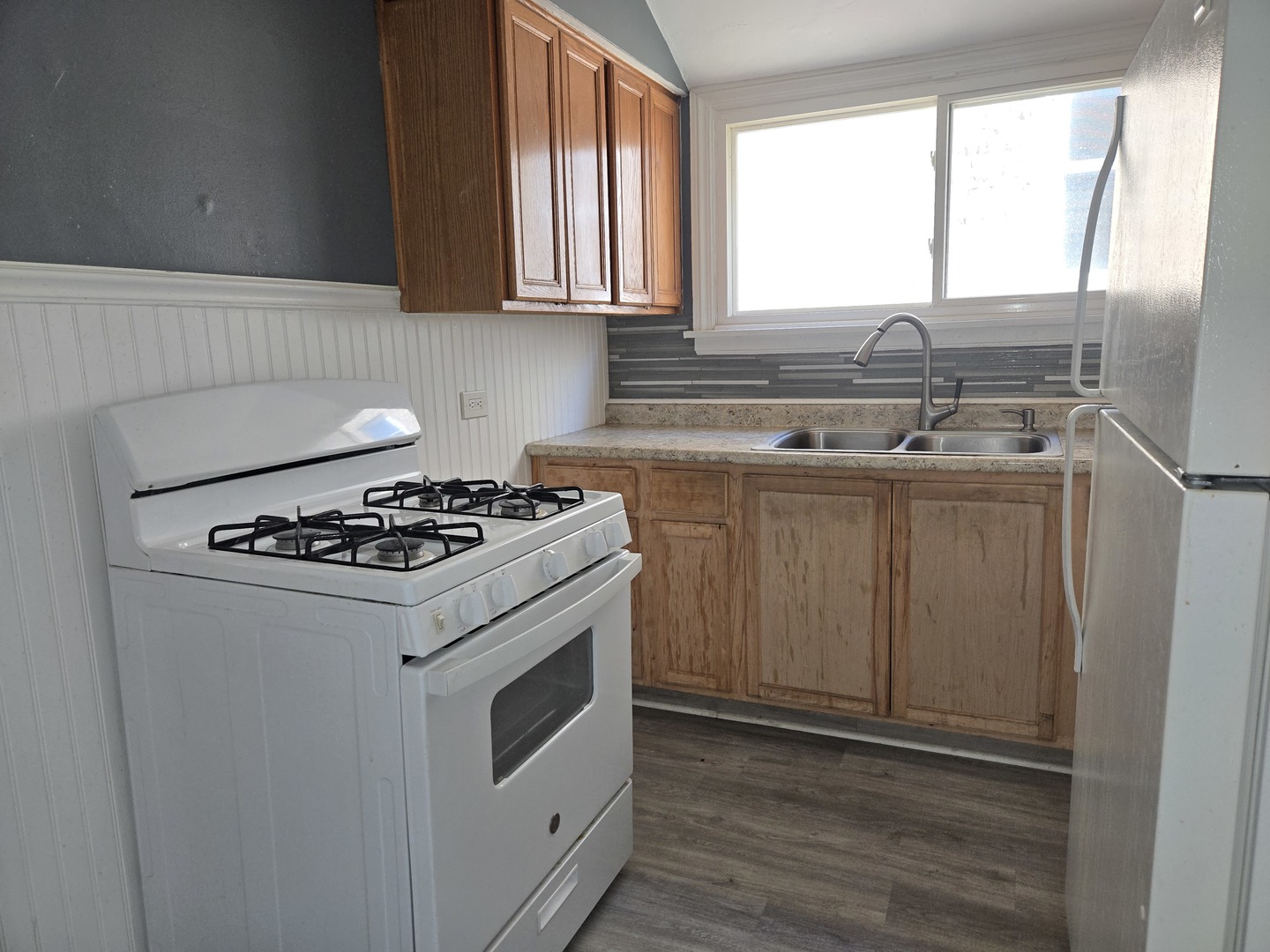 5204 West Newport Avenue, Unit 2 Chicago, IL 60641 - Photo 6 of 10 a kitchen with a stove a sink and a window