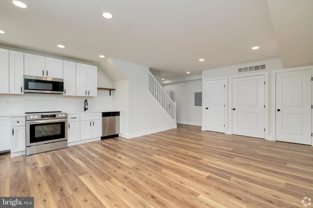 a view of kitchen with granite countertop stove top oven and cabinets