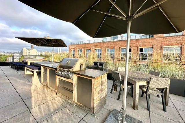 a view of a patio with table and chairs under an umbrella