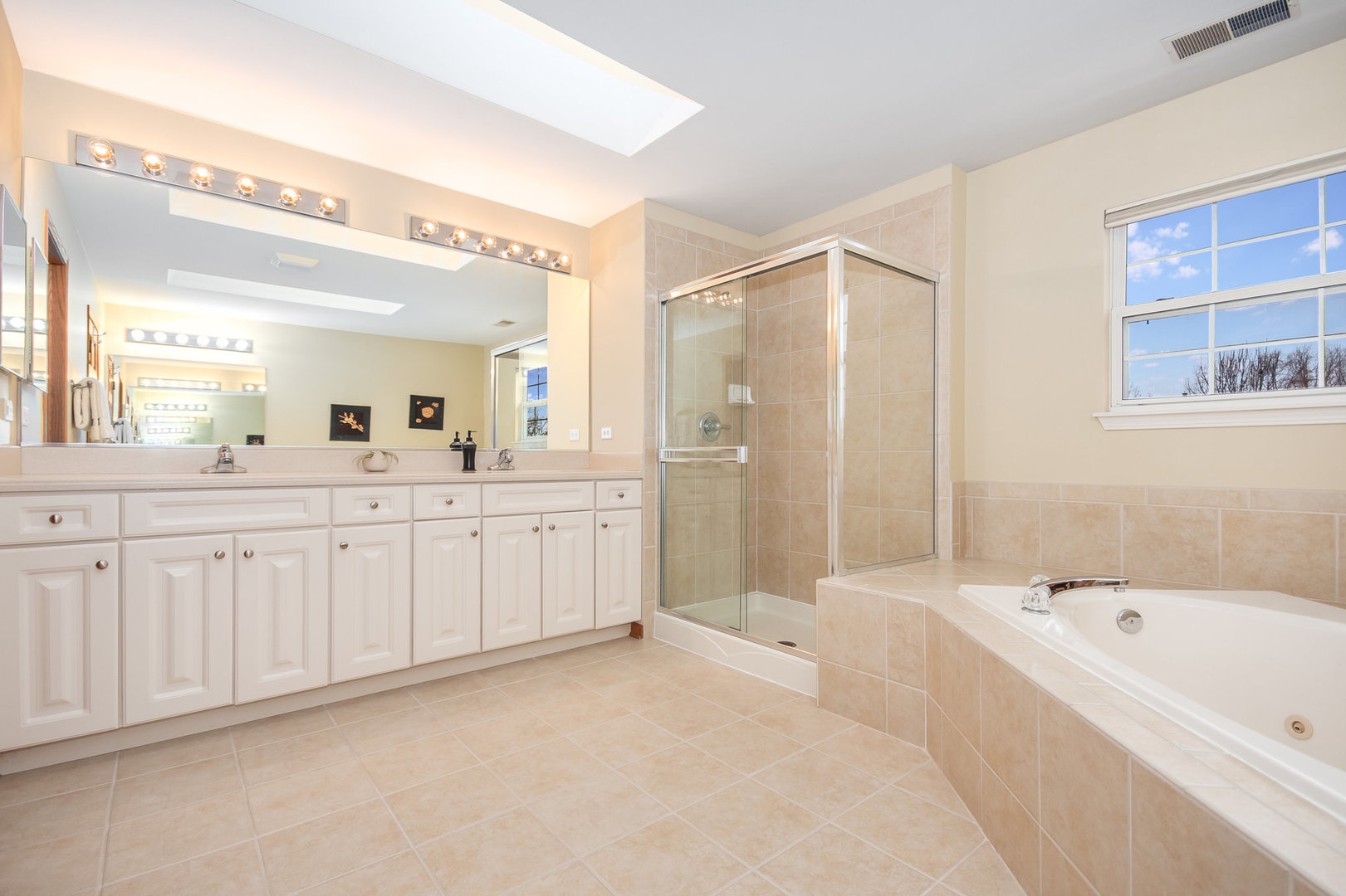 712 Eagle Brook Lane Naperville, IL 60565 - Photo 21 of 40 a spacious bathroom with a double vanity sink a mirror a bathtub and shower