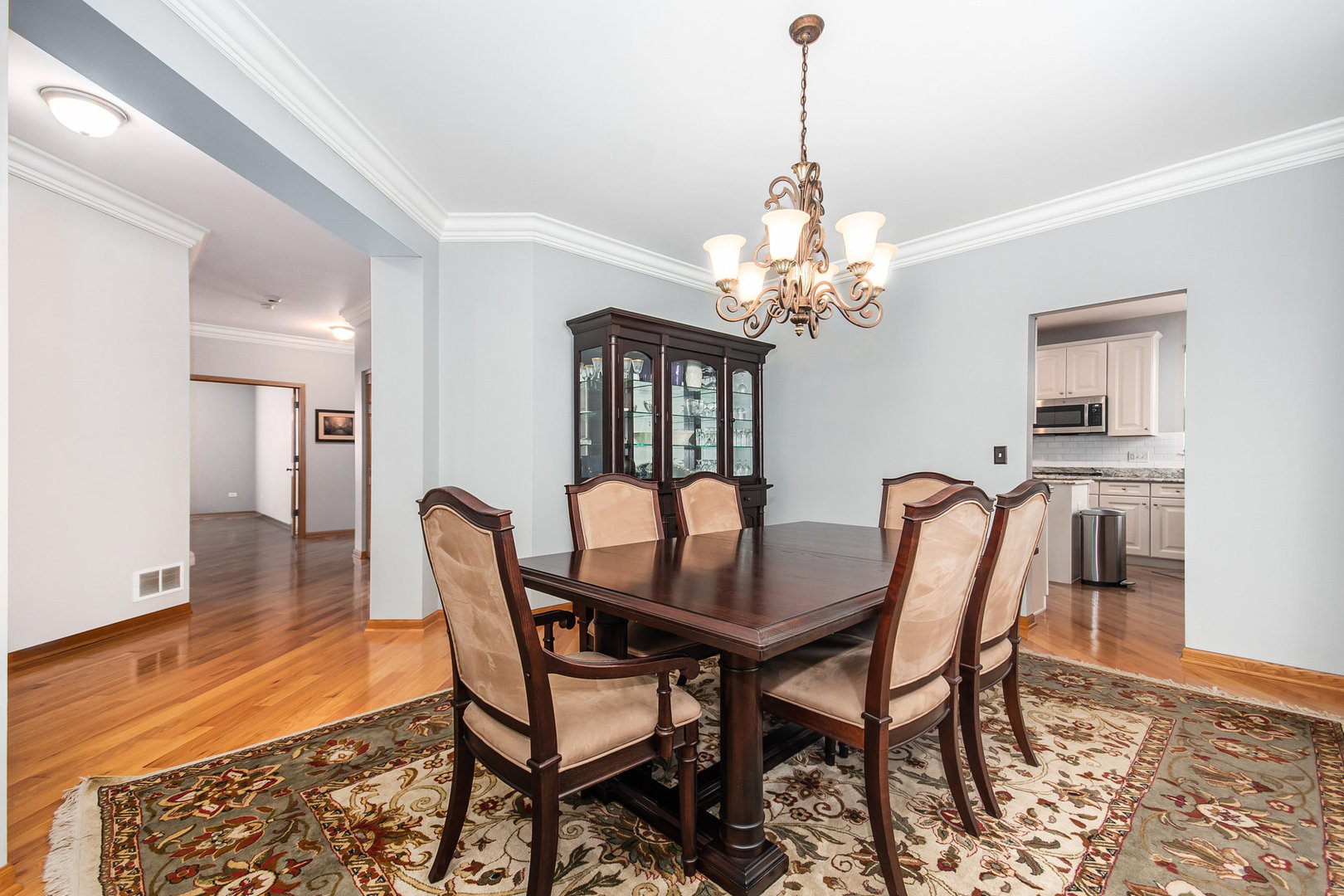 712 Eagle Brook Lane Naperville, IL 60565 - Photo 10 of 40 a dining room with furniture a chandelier and wooden floor