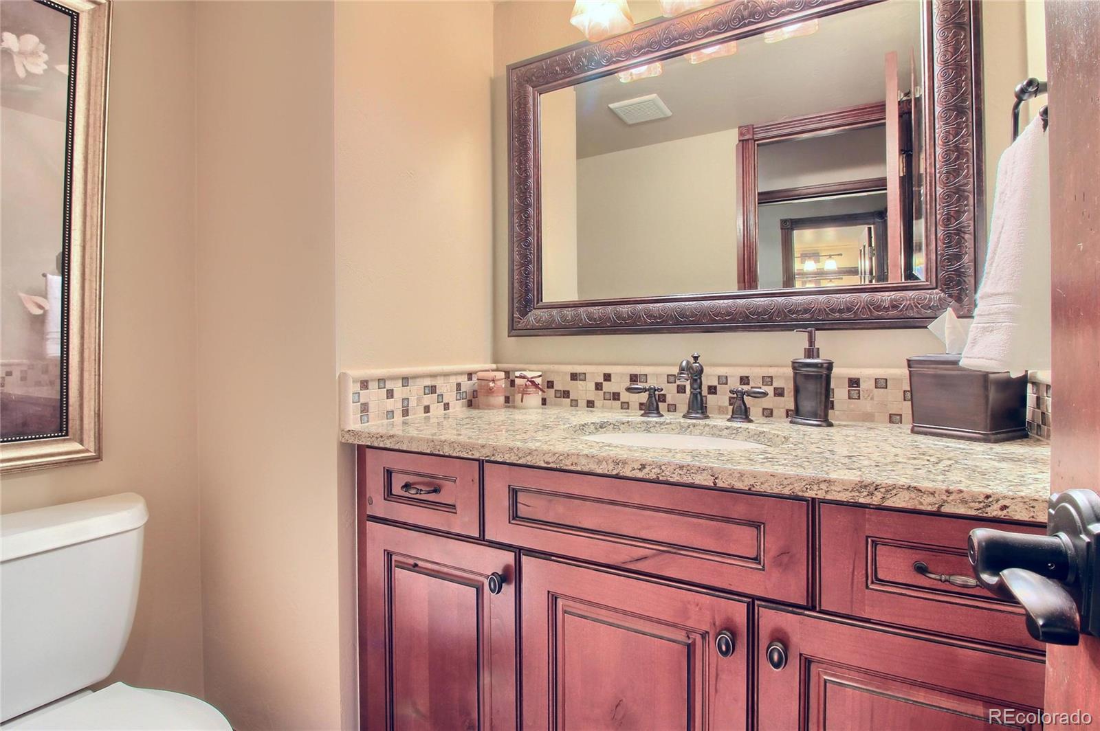 5661 West Lakeridge Road Lakewood, CO 80227 - Photo 12 of 35 a bathroom with a granite countertop sink and a toilet