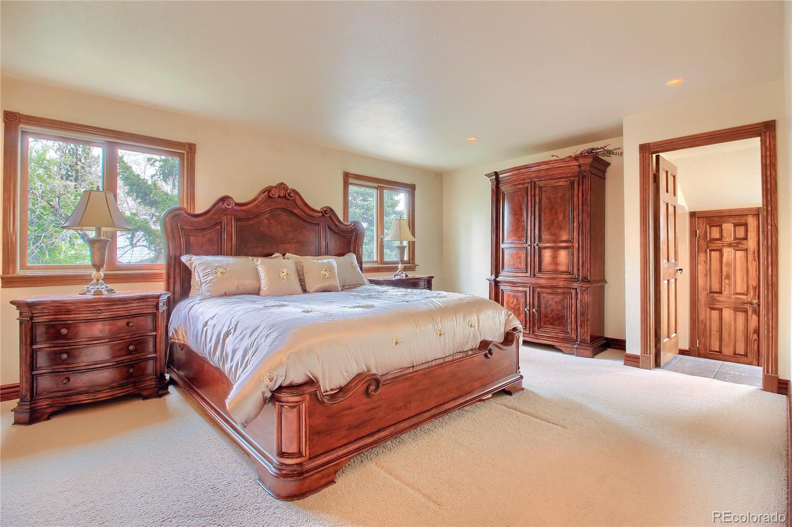 5661 West Lakeridge Road Lakewood, CO 80227 - Photo 15 of 35 a spacious bedroom with a bed and a dresser next to a window