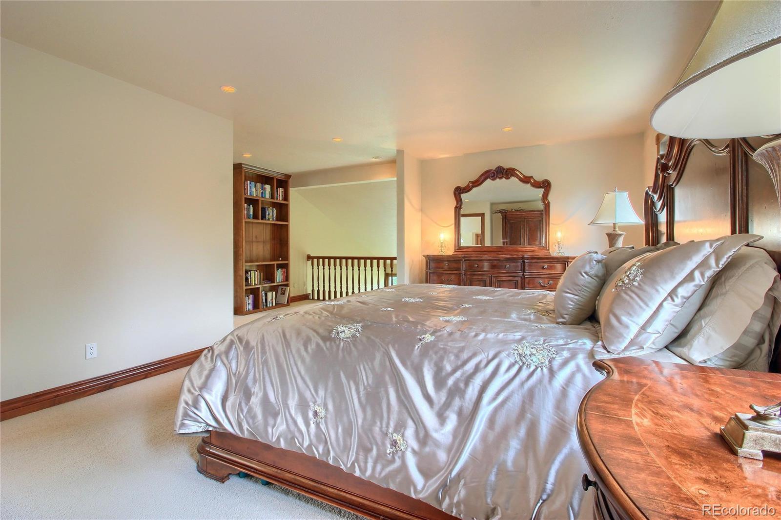 5661 West Lakeridge Road Lakewood, CO 80227 - Photo 16 of 35 a bedroom with a bed and a lamp on dresser