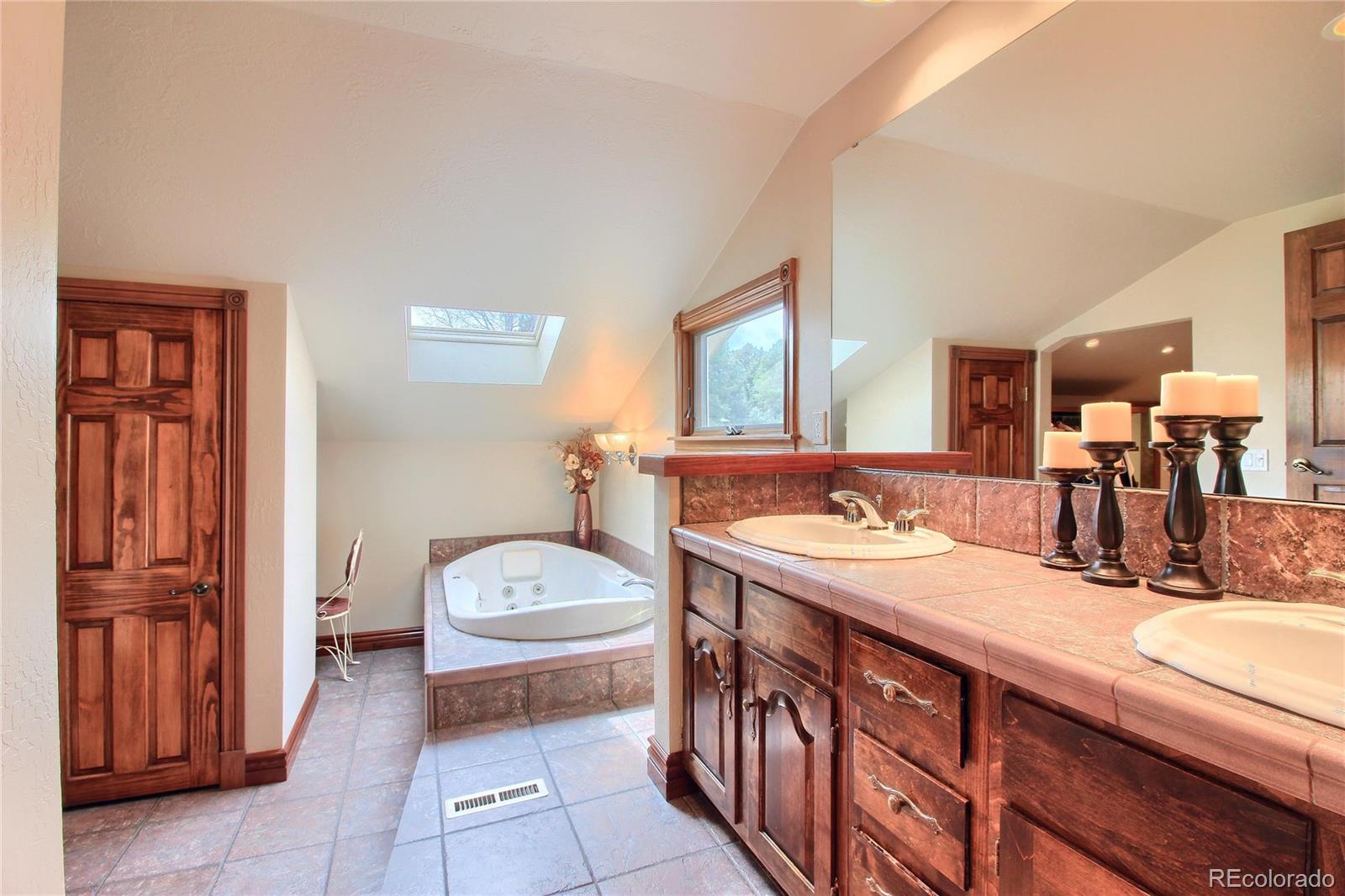 5661 West Lakeridge Road Lakewood, CO 80227 - Photo 19 of 35 a bathroom with a sink double vanity and a tub