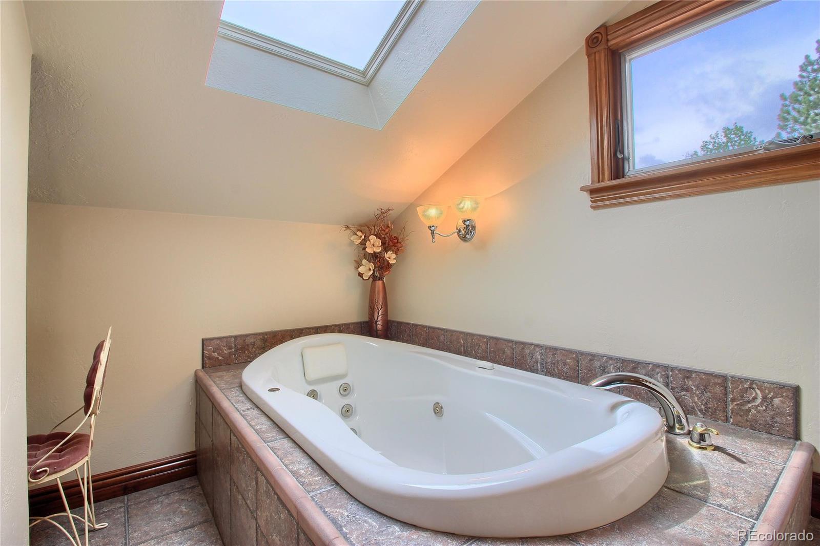 5661 West Lakeridge Road Lakewood, CO 80227 - Photo 20 of 35 a view of a bathtub in a bathroom