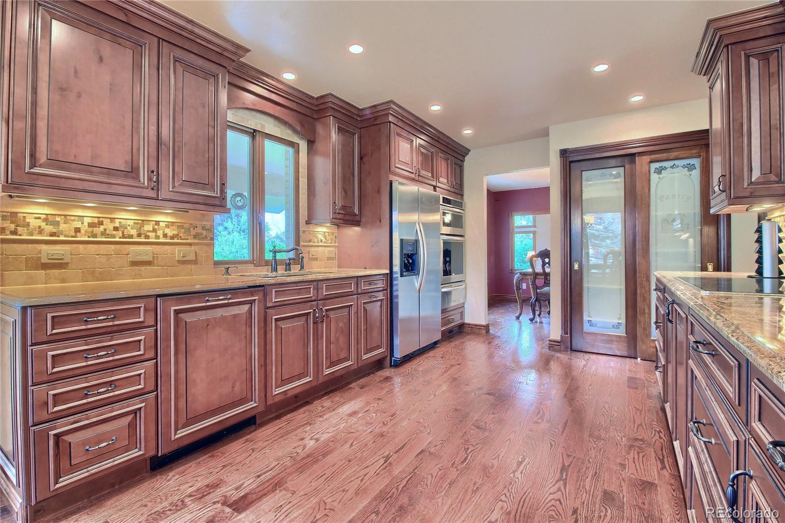 5661 West Lakeridge Road Lakewood, CO 80227 - Photo 2 of 35 a open kitchen with stainless steel appliances granite countertop a sink and wooden cabinets with wooden floors
