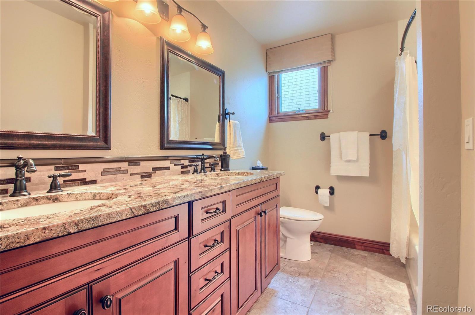 5661 West Lakeridge Road Lakewood, CO 80227 - Photo 26 of 35 a bathroom with a granite countertop toilet sink and mirror