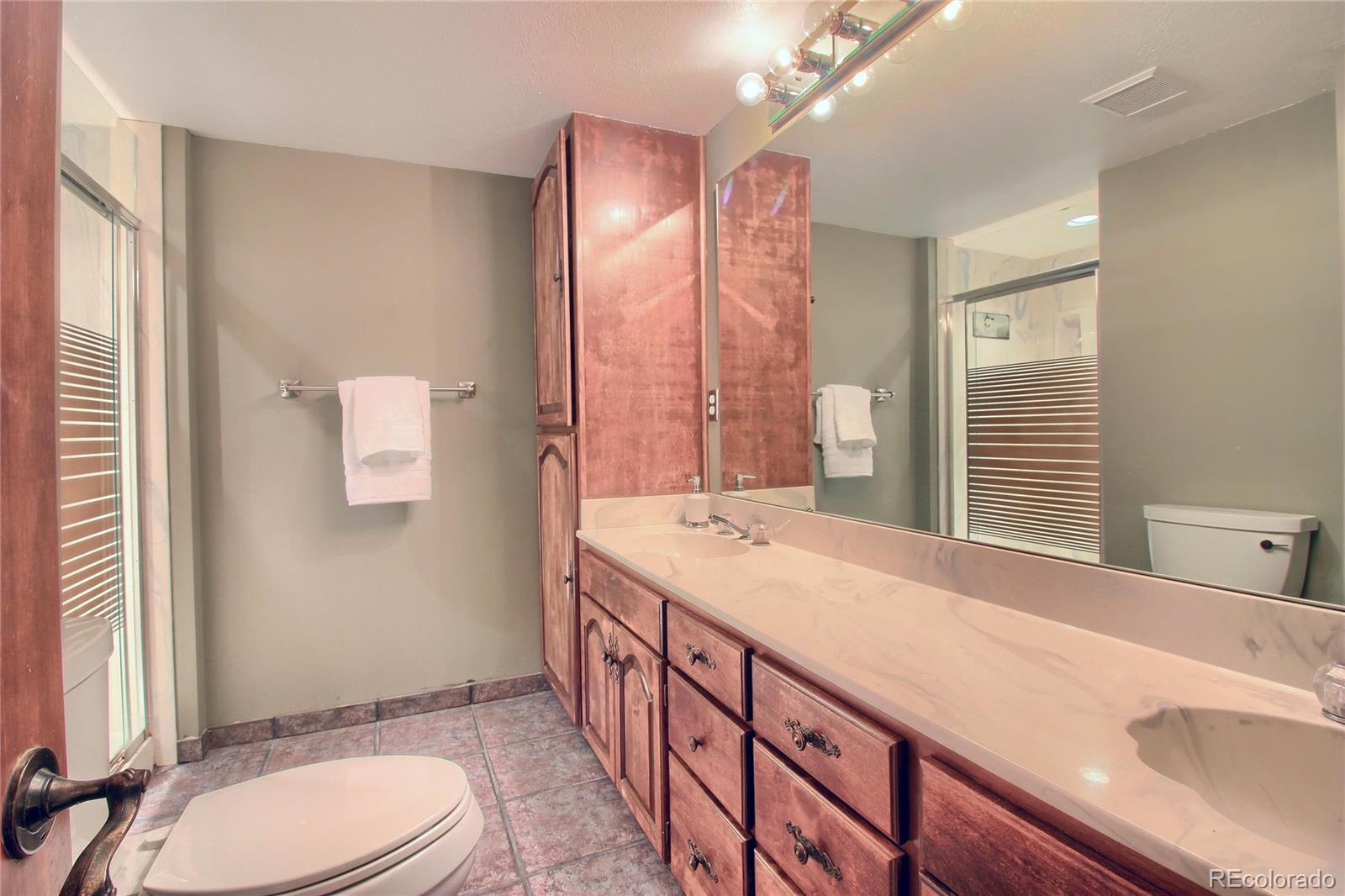 5661 West Lakeridge Road Lakewood, CO 80227 - Photo 27 of 35 a bathroom with a sink a toilet and large mirror