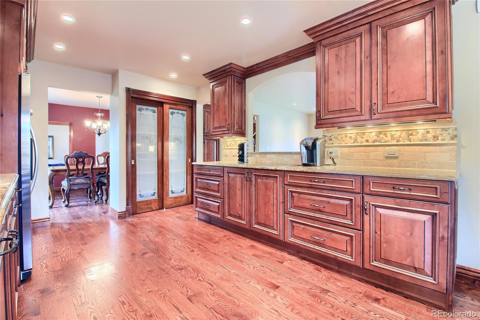 5661 West Lakeridge Road Lakewood, CO 80227 - Photo 3 of 35 a view of a kitchen with stainless steel appliances granite countertop wooden cabinets a sink and dishwasher with a large window
