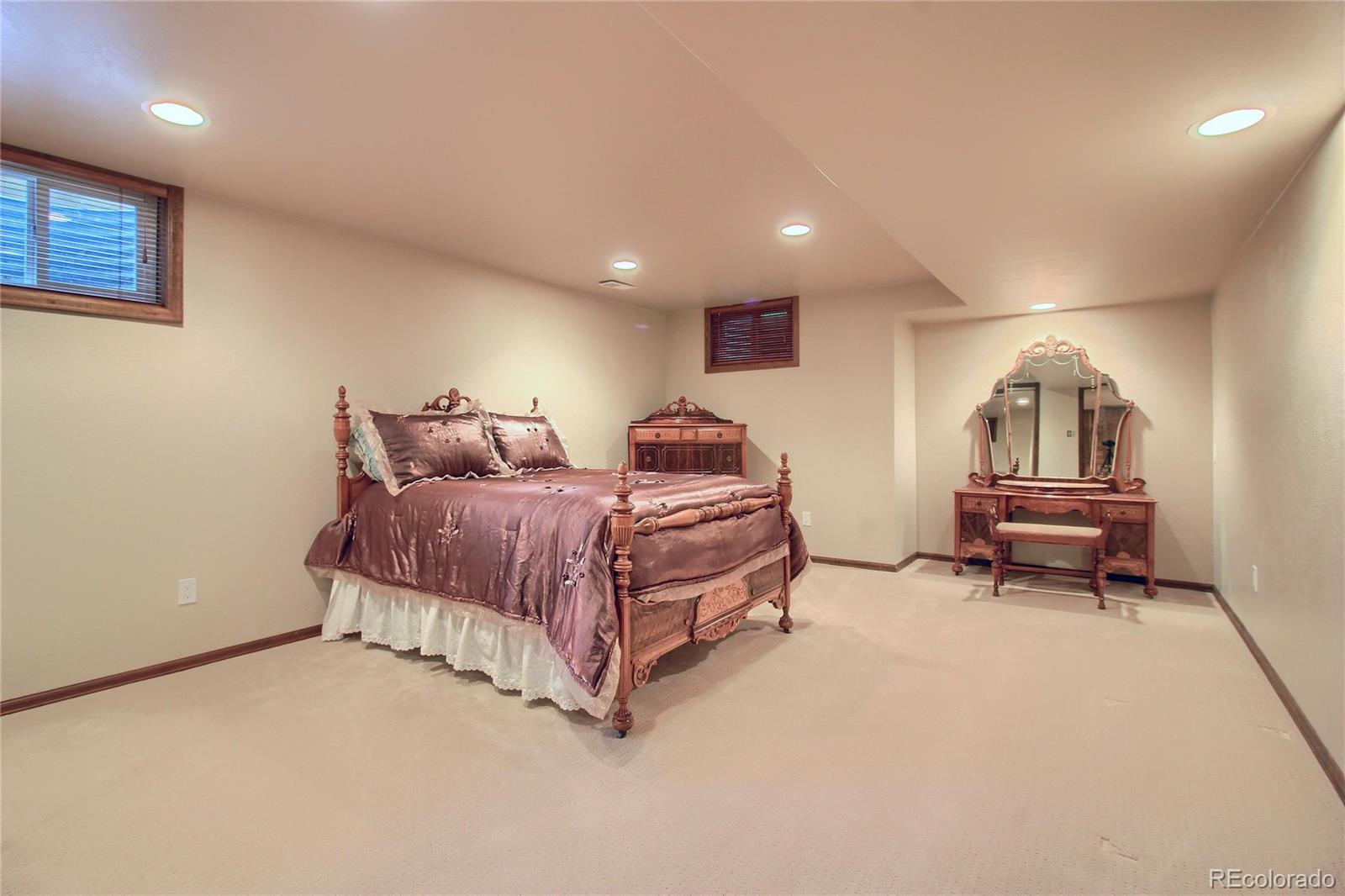 5661 West Lakeridge Road Lakewood, CO 80227 - Photo 35 of 35 a spacious bedroom with a bed and a chandelier