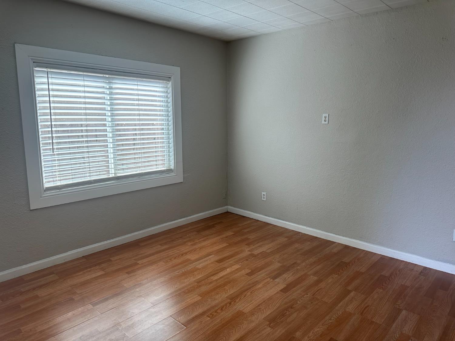 1235 N Street Newman, CA 95360 - Photo 19 of 33 a view of an empty room with wooden floor and a window