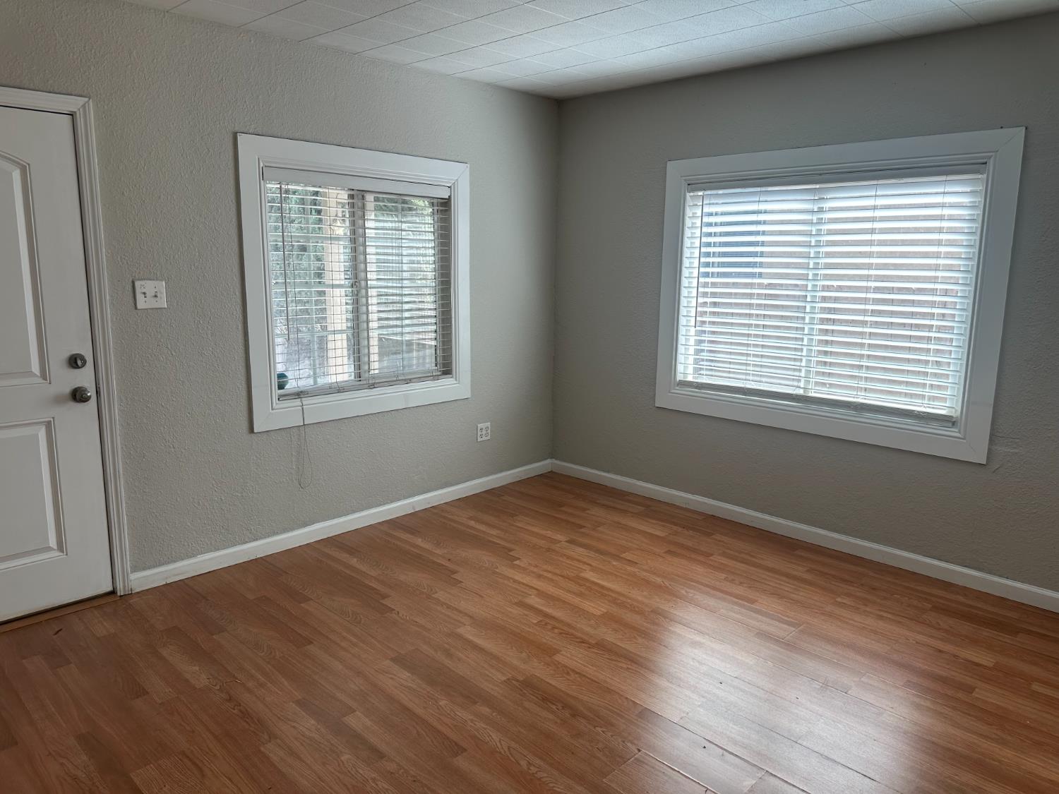 1235 N Street Newman, CA 95360 - Photo 21 of 33 a view of an empty room with wooden floor and a window