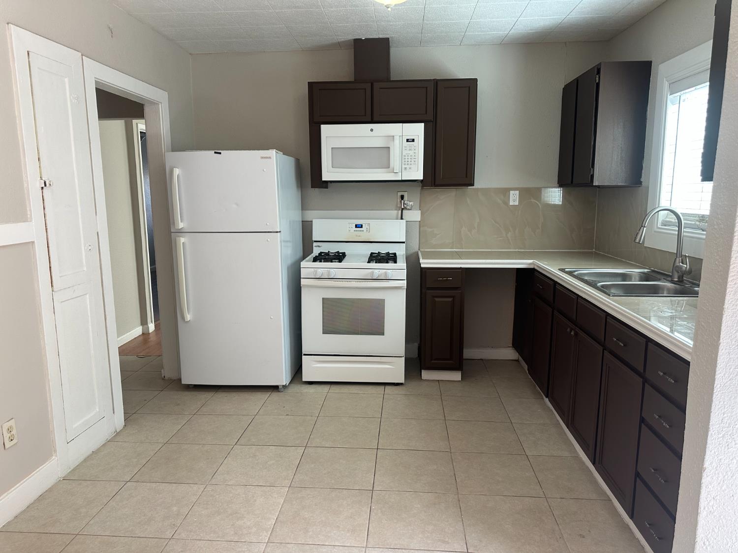 1235 N Street Newman, CA 95360 - Photo 25 of 33 a kitchen with a refrigerator sink stove and cabinets