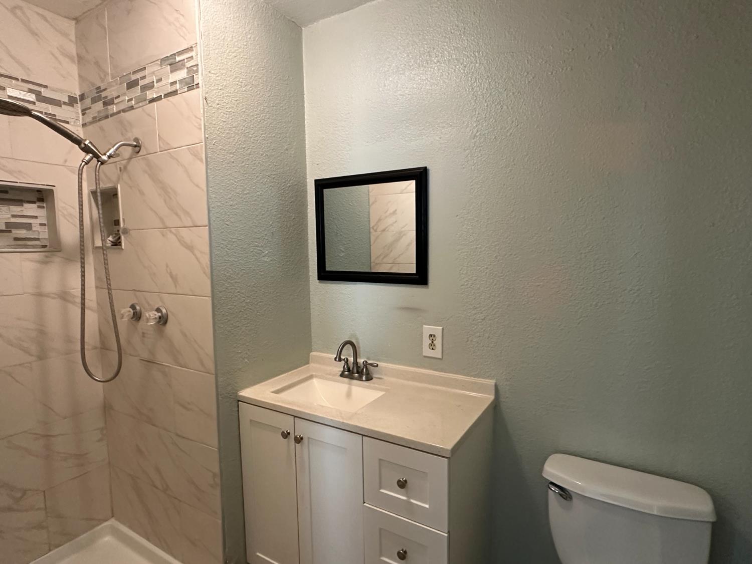 1235 N Street Newman, CA 95360 - Photo 30 of 33 a bathroom with a granite countertop toilet sink and mirror