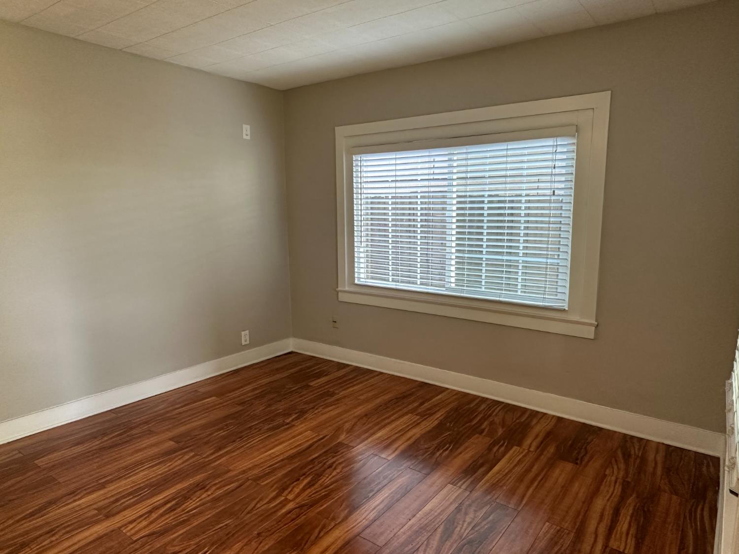 1235 N Street Newman, CA 95360 - Photo 3 of 33 a view of an empty room with wooden floor and a window