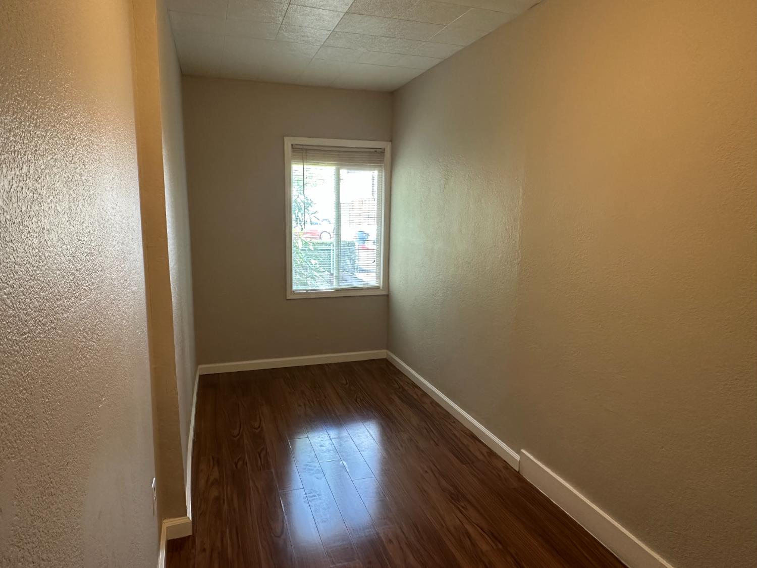 1235 N Street Newman, CA 95360 - Photo 5 of 33 an empty room with wooden floor and windows