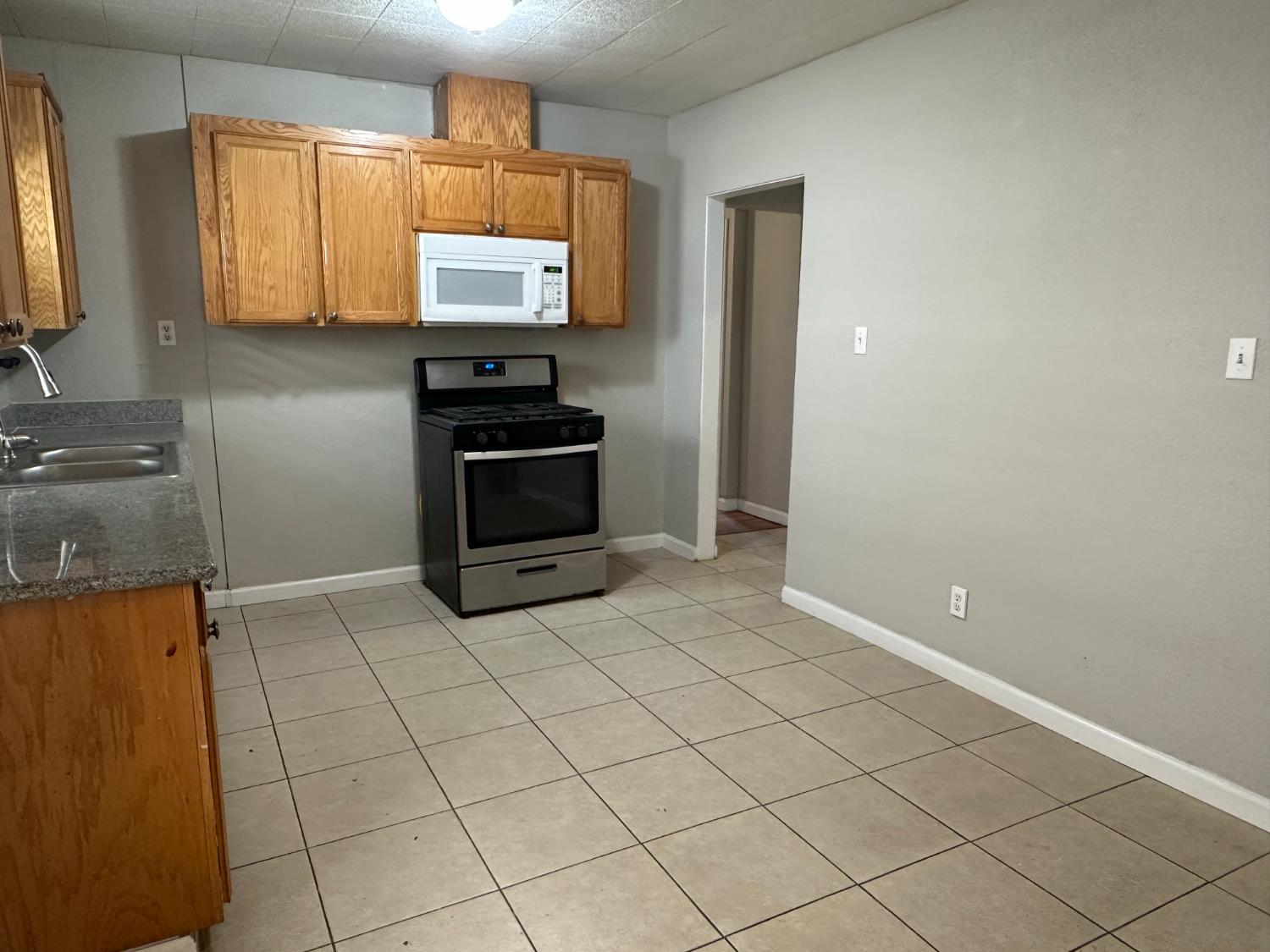 1235 N Street Newman, CA 95360 - Photo 9 of 33 a kitchen with stainless steel appliances a stove a sink and a microwave