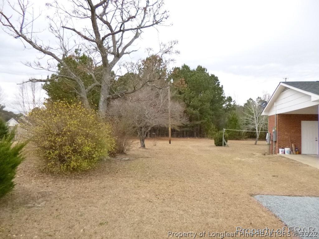 5135 Murphy Road Stedman, NC 28391 - Photo 32 of 33 a backyard of a house with large trees and wooden fence