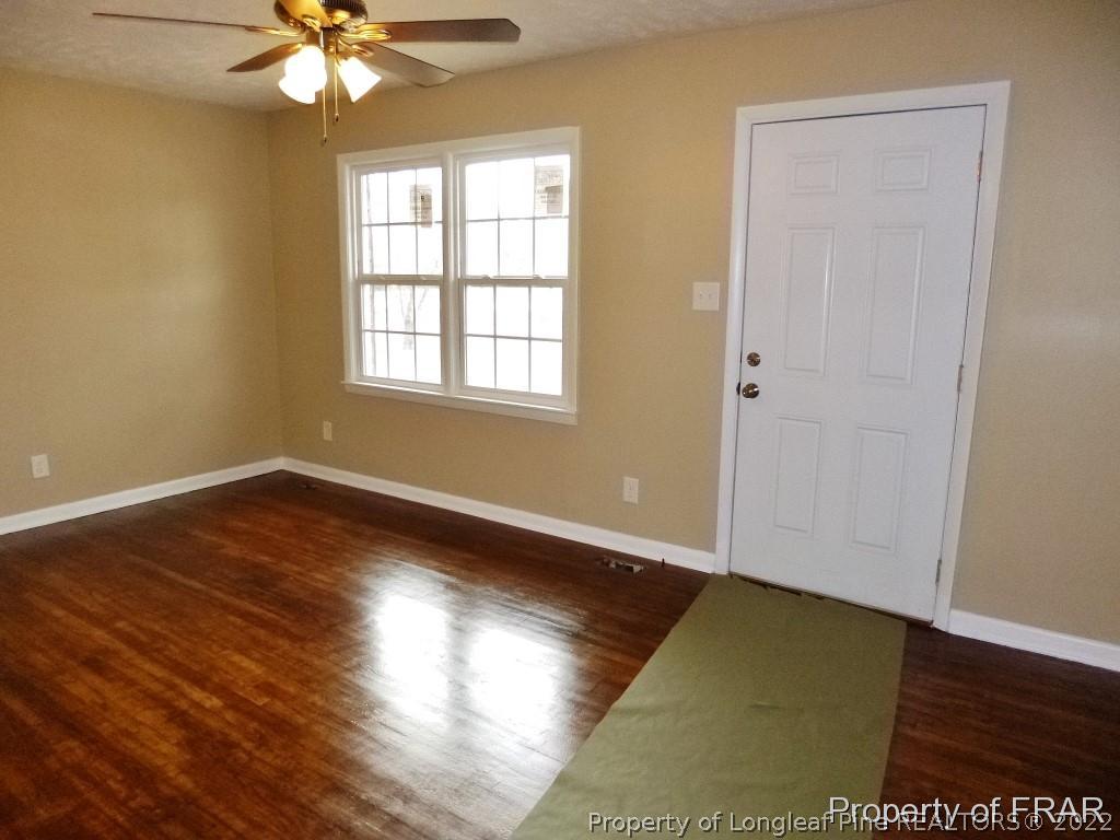 5135 Murphy Road Stedman, NC 28391 - Photo 4 of 33 an empty room with wooden floor and windows