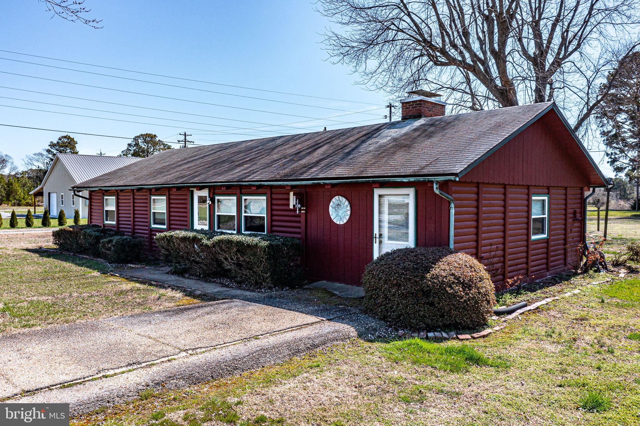 Charming red cottage with lush greenery.