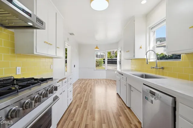 a kitchen with a sink and wooden floor