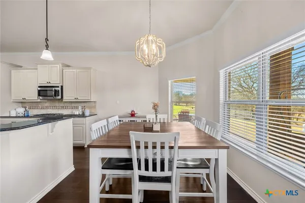 a view of a dining room with furniture a chandelier and wooden floor