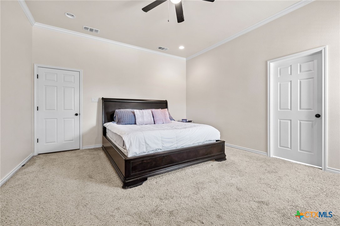 957 County Road 3350 Kempner, TX 76539 - Photo 16 of 35 a spacious bedroom with a bed and a ceiling fan