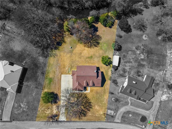 an aerial view of a house with a yard and lake view