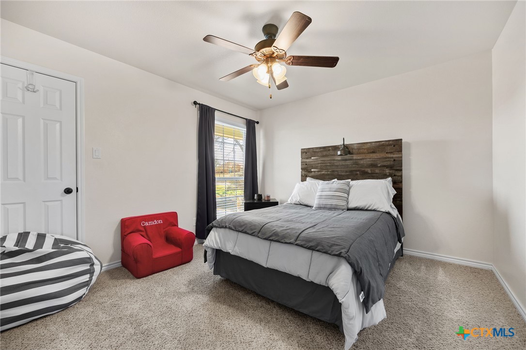 957 County Road 3350 Kempner, TX 76539 - Photo 22 of 35 a bedroom with bed and a chandelier