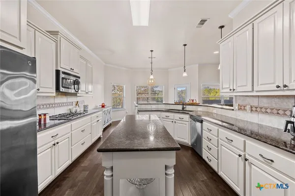 a kitchen with stainless steel appliances granite countertop a sink stove and refrigerator