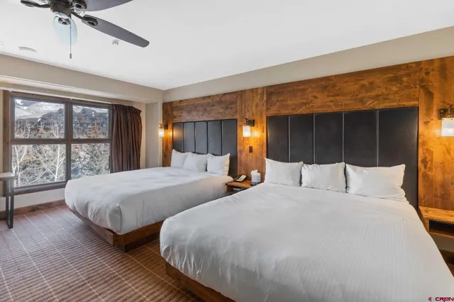 a bedroom with two beds and a large window