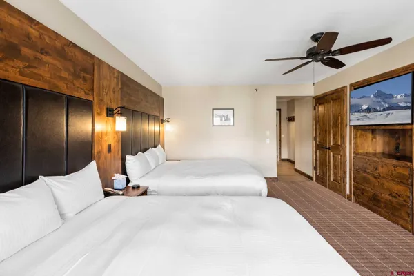 a bedroom with two beds and a large window