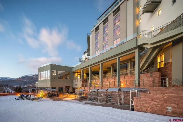 a city street lined with parked cars front of building