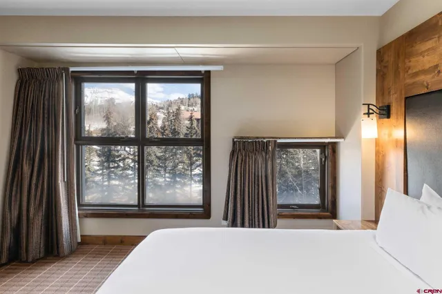 a bedroom with a large window and a bed