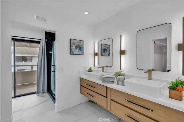 a bathroom with double vanity sinks and a mirror