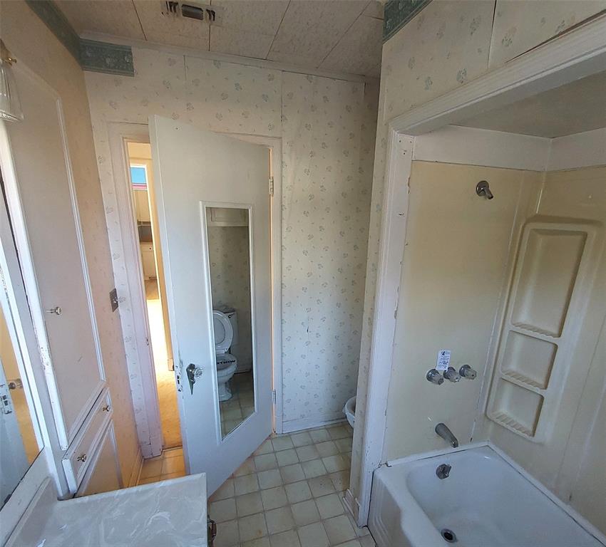 2131 Hubbard Street Paris, TX 75460 - Photo 9 of 14 a bathroom with a tub a sink and a mirror
